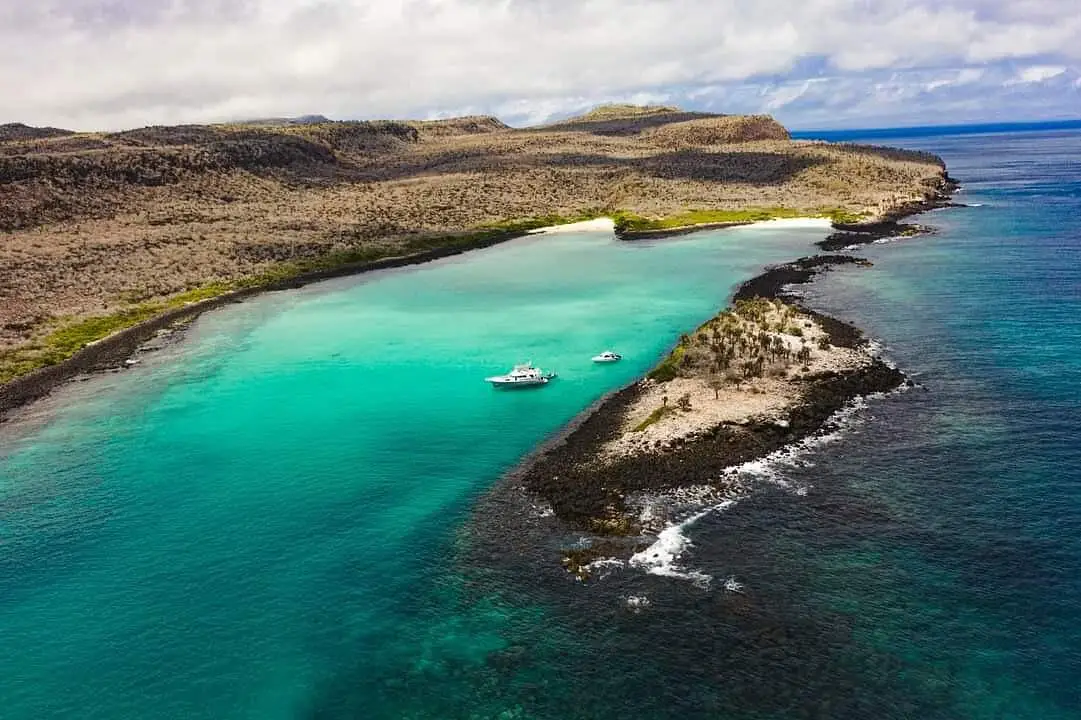 Vista aérea de la bahía turquesa y costa rocosa de Isla Santa Fe, Galápagos