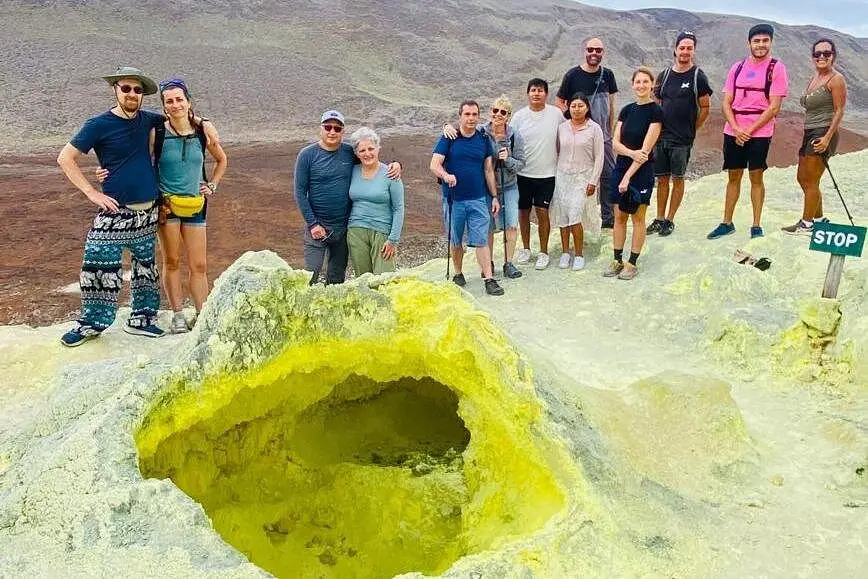 Turistas explorando las formaciones volcánicas amarillas de las Minas de Azufre